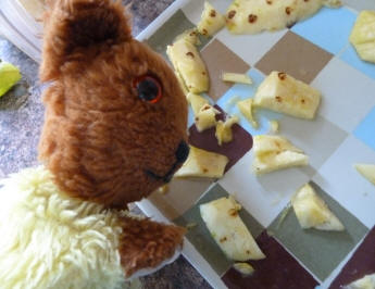 Yellow Teddy cutting up pineapple