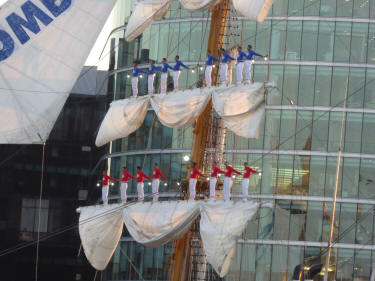 Men standing on beams of sailing ship