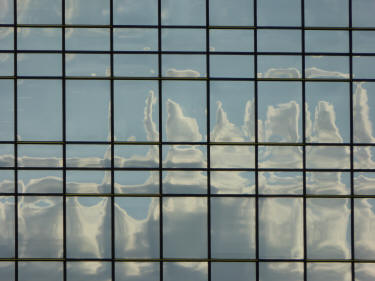 Glass building reflecting sky and clouds